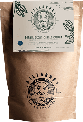 Brown paper coffee bag from Killarney Coffee Roasters with a cream and green label that reads "Brazil Decaf Single Origin." The design features hand-drawn botanical illustrations and the roaster’s logo. The coffee is 100% Arabica and available as whole bean.