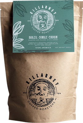 Brown paper coffee bag from Killarney Coffee Roasters featuring a green label with white botanical illustrations. The label highlights "Brazil Single Origin" 100% Arabica coffee with roast and origin details.