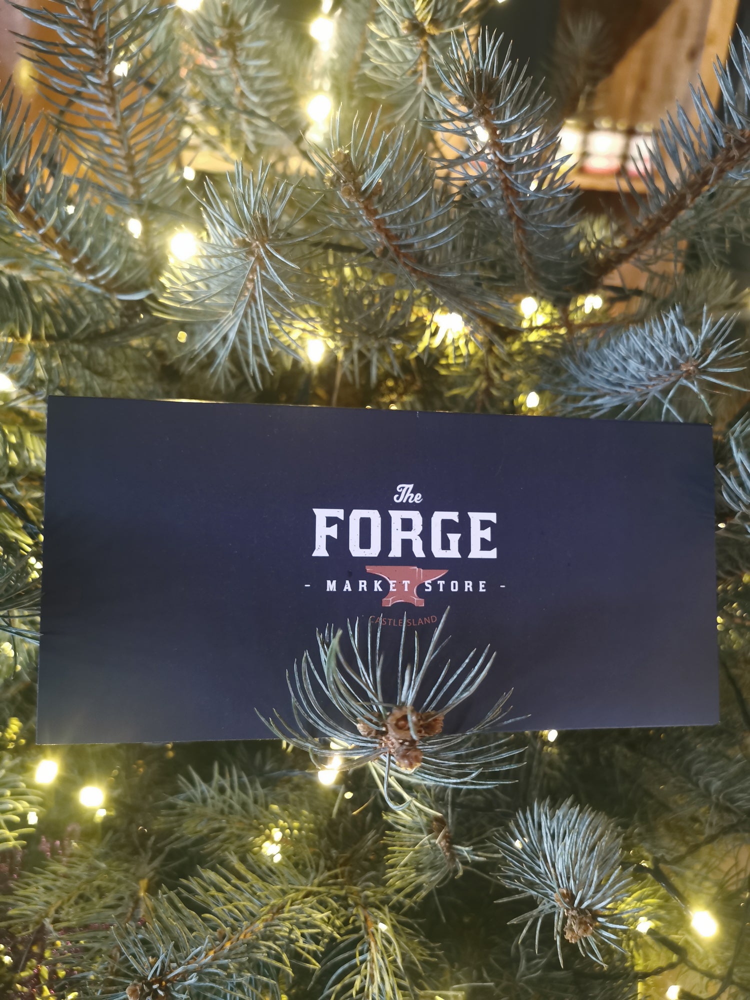 A Forge branded gift card displayed on a Christmas tree, with the brand name and logo visible.